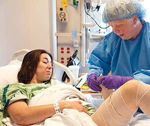 Nurse Carol Burk assists patient