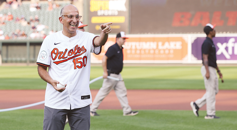 Dr. David Maine, president and CEO of Mercy Health Services of Baltimore, throws out the ceremonial first pitch