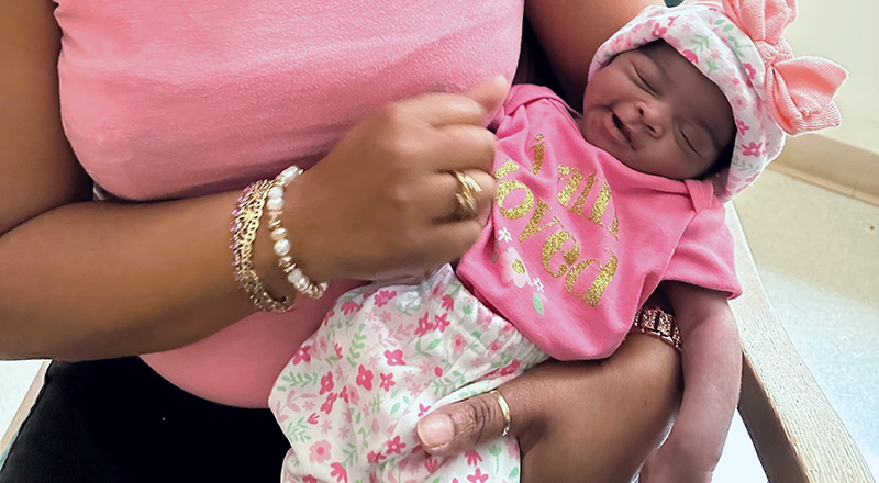 A certified medical assistant and doula, cradles a baby