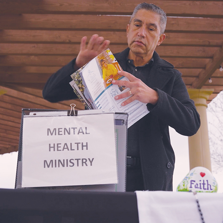 Estaban Quintana prepares materials he was helping to distribute on mental health awareness.