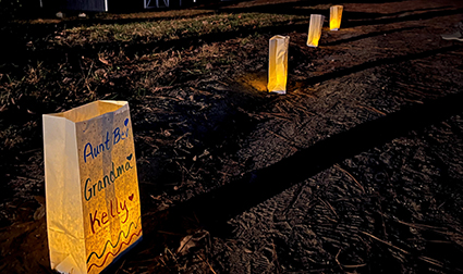 Luminarias with names of deceased family members line a walkway at Mikey’s Camp, a part of a program called KIDZ’NGRIEF.