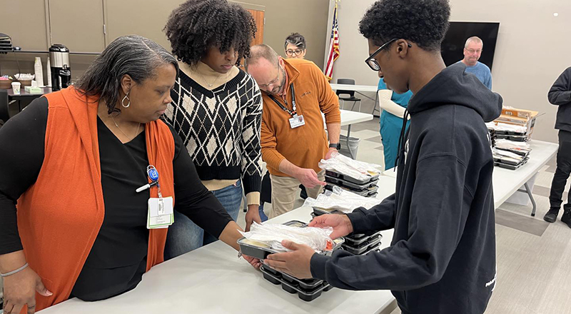 Family members of the pop star Usher help to distribute holiday meals