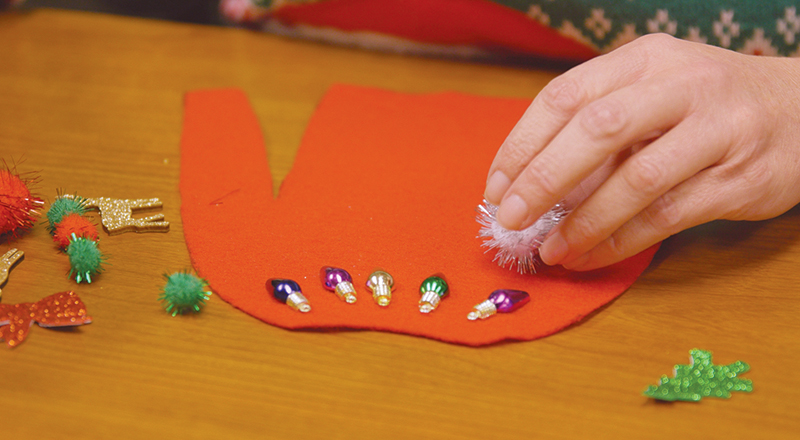 Woman's hands making a tiny sweater.