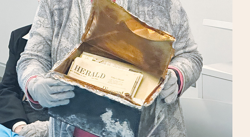 Sr. Beverly Raway, prioress of the Benedictine Sisters of the St. Scholastica Monastery, exposes the contents of a time capsule.