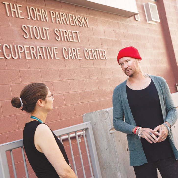 Sara Keith, Colorado Coalition for the Homeless manager of patient activities and volunteers, talks with Casey Capper outside the John Parvensky Stout Street Recuperative Care Center in Denver.